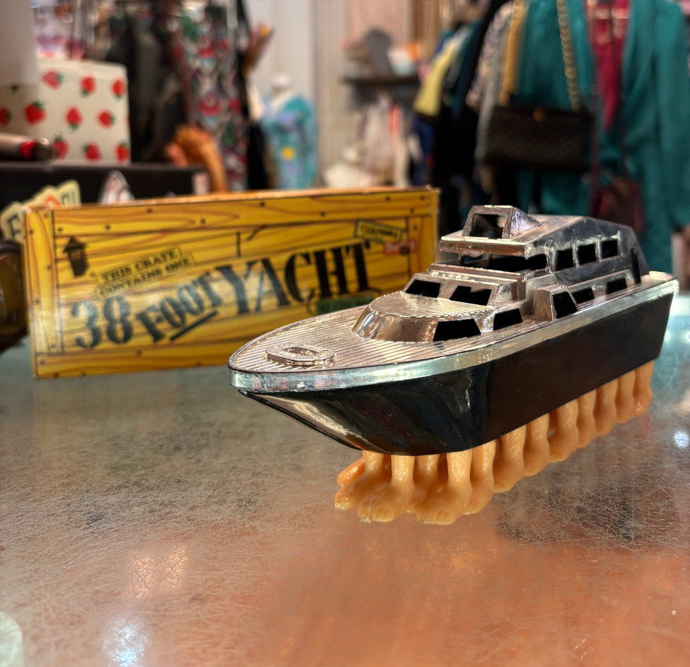 Model boat on a stand with a blurred store interior in the background