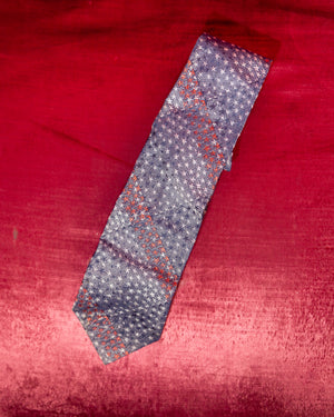 Patterned tie on a red fabric background