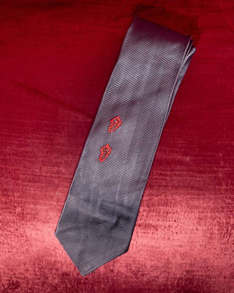 Gray tie with red patterns on a red textured background