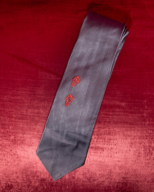 Gray tie with red patterns on a red textured background