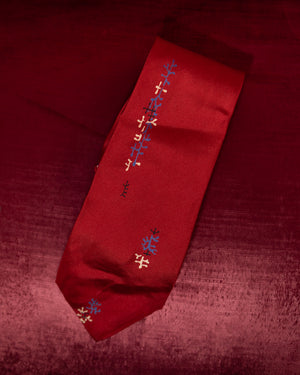 Red tie with embroidered patterns on a red background
