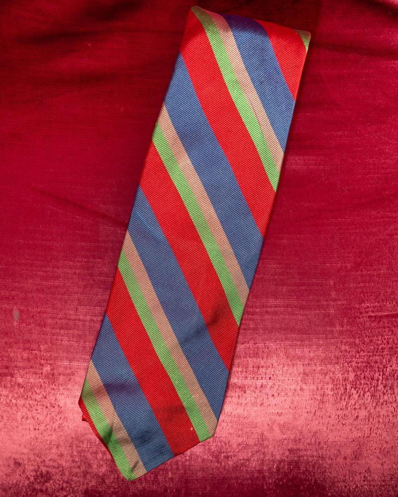 Striped tie with red, blue, and green pattern on a red fabric background