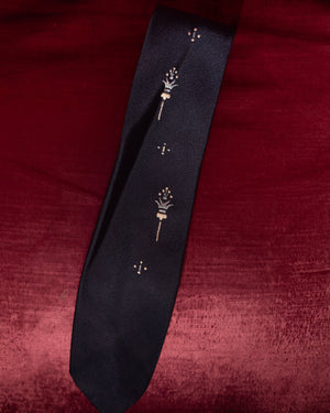 Black tie with gold designs on a red fabric background