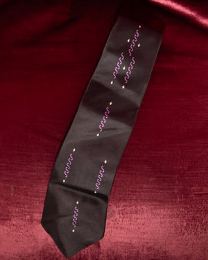 Black tie with white text on a red fabric background
