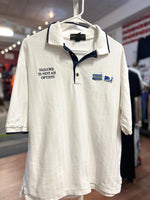 White polo shirt with text and logo on a hanger in a store setting